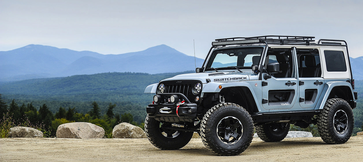Jeep Wrangler on a scenic road with mountains in the background
