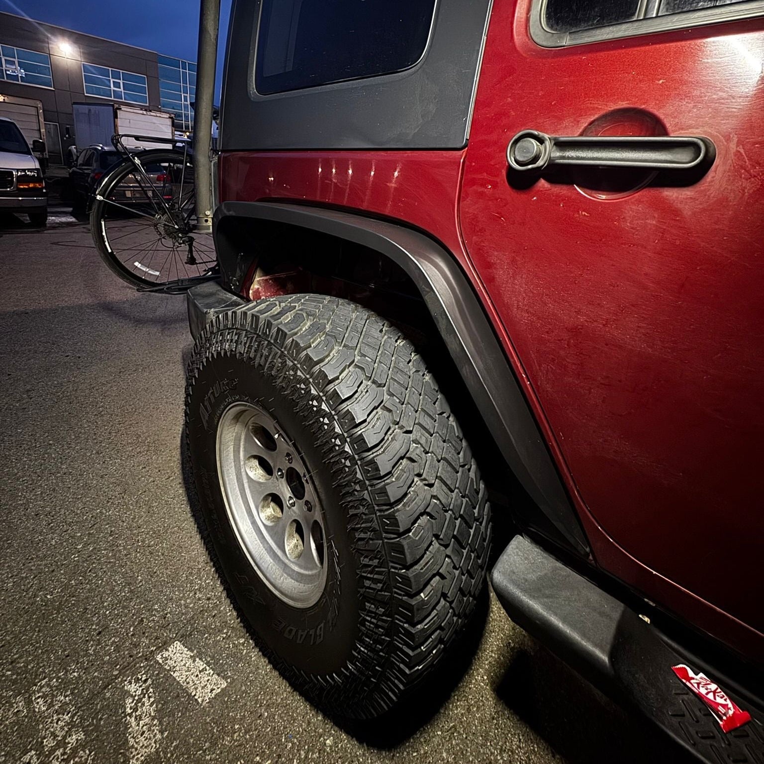 close-up of 2007–2018 Jeep Wrangler JK slim fender flares installed on red Rubicon Wrangler