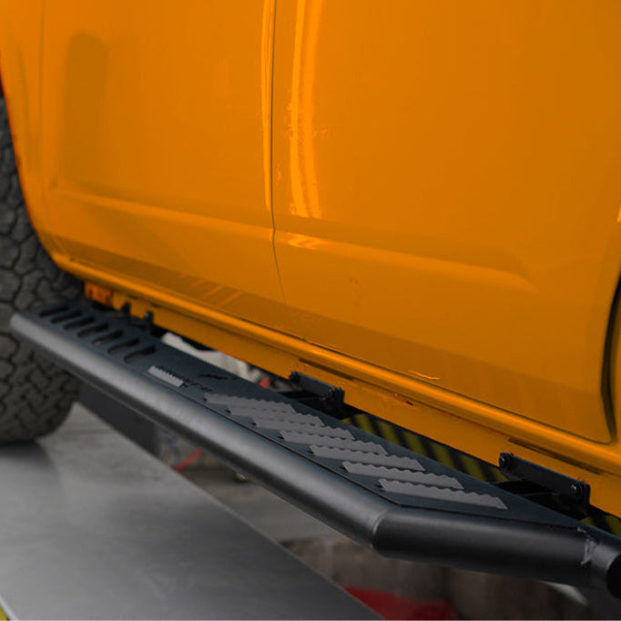 2021–2026 Ford Bronco 4-door OE+ side steps installed on orange Bronco showing OEM-style fit and appearance