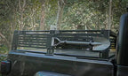Black truck bed with a metal tool rack and shovel, set against a natural background.