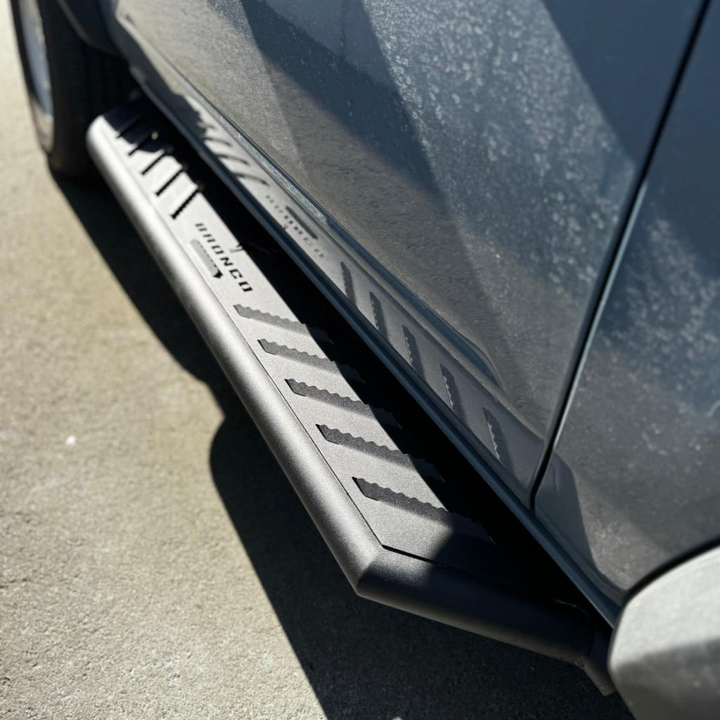 Close up of running boards installed on blue 2021-2025 Ford Bronco 2 door textured black side steps