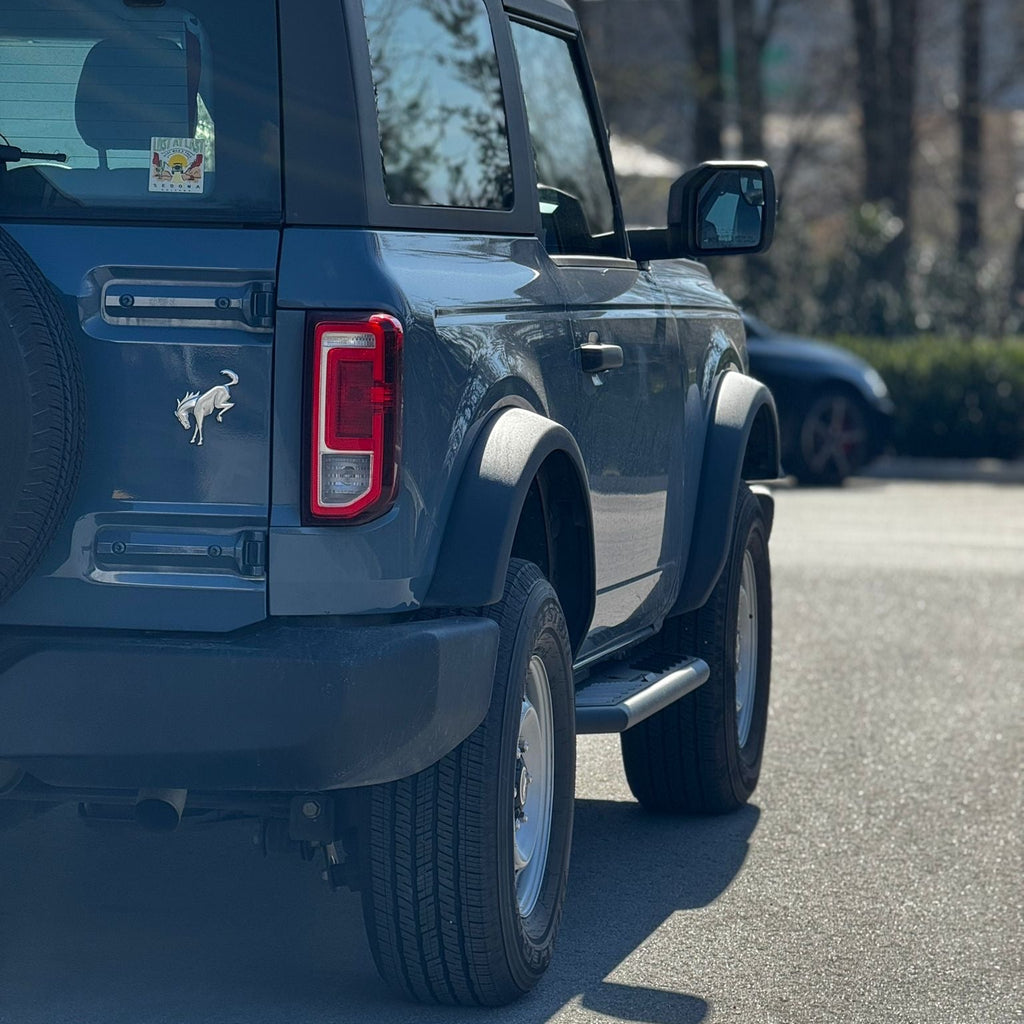 Rear view of running boards installed on blue 2021-2025 Ford Bronco 2 door textured black side steps