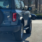 Rear view of running boards installed on blue 2021-2025 Ford Bronco 2 door textured black side steps